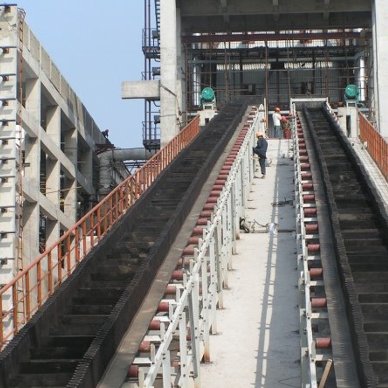 Silo incliné alimentant le convoyeur à bande de jupe en béton avec déflecteur